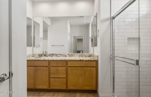 a bathroom with a granite countertop sink mirror and shower