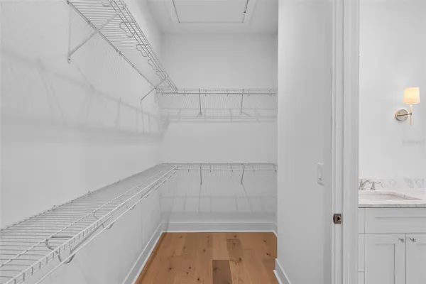 a view of an empty room with wooden floor and closet