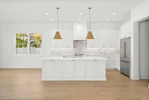 a kitchen with stainless steel appliances granite countertop a sink a stove a refrigerator and window