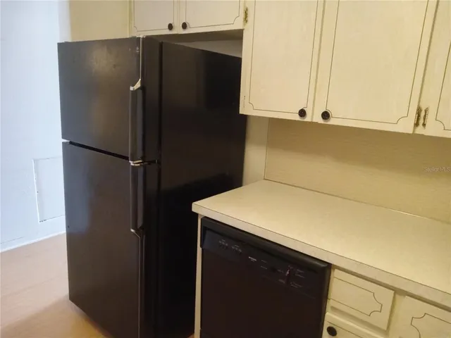 a kitchen with a refrigerator and cabinets