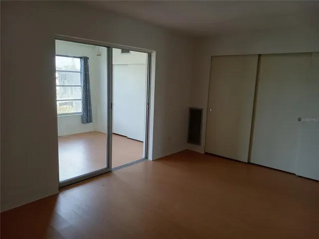 an empty room with closet and windows