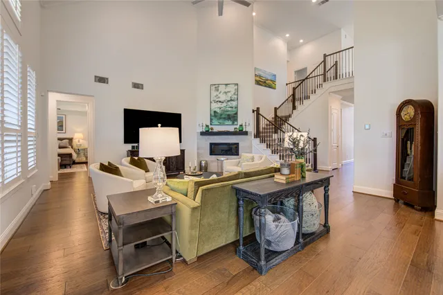 a view of a livingroom with furniture a rug wooden floor and windows