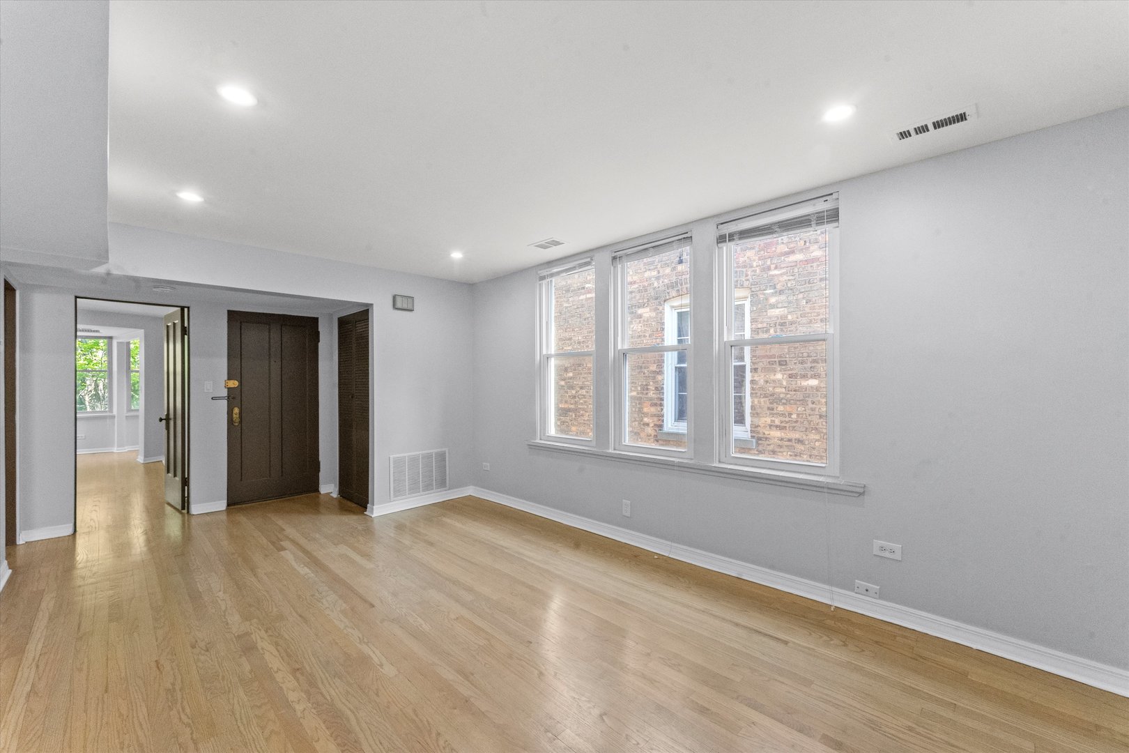 4846 North Keystone Avenue, Unit 2 Chicago, IL 60630 - Photo 3 of 12 an empty room with wooden floor and windows