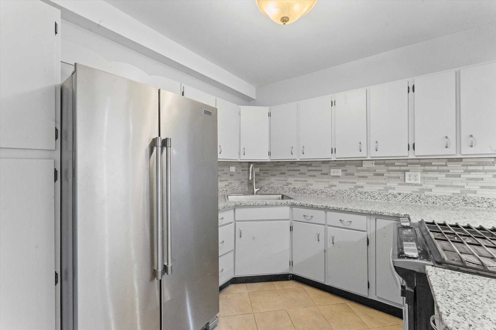 4846 North Keystone Avenue, Unit 2 Chicago, IL 60630 - Photo 5 of 12 a kitchen with white cabinets and white appliances
