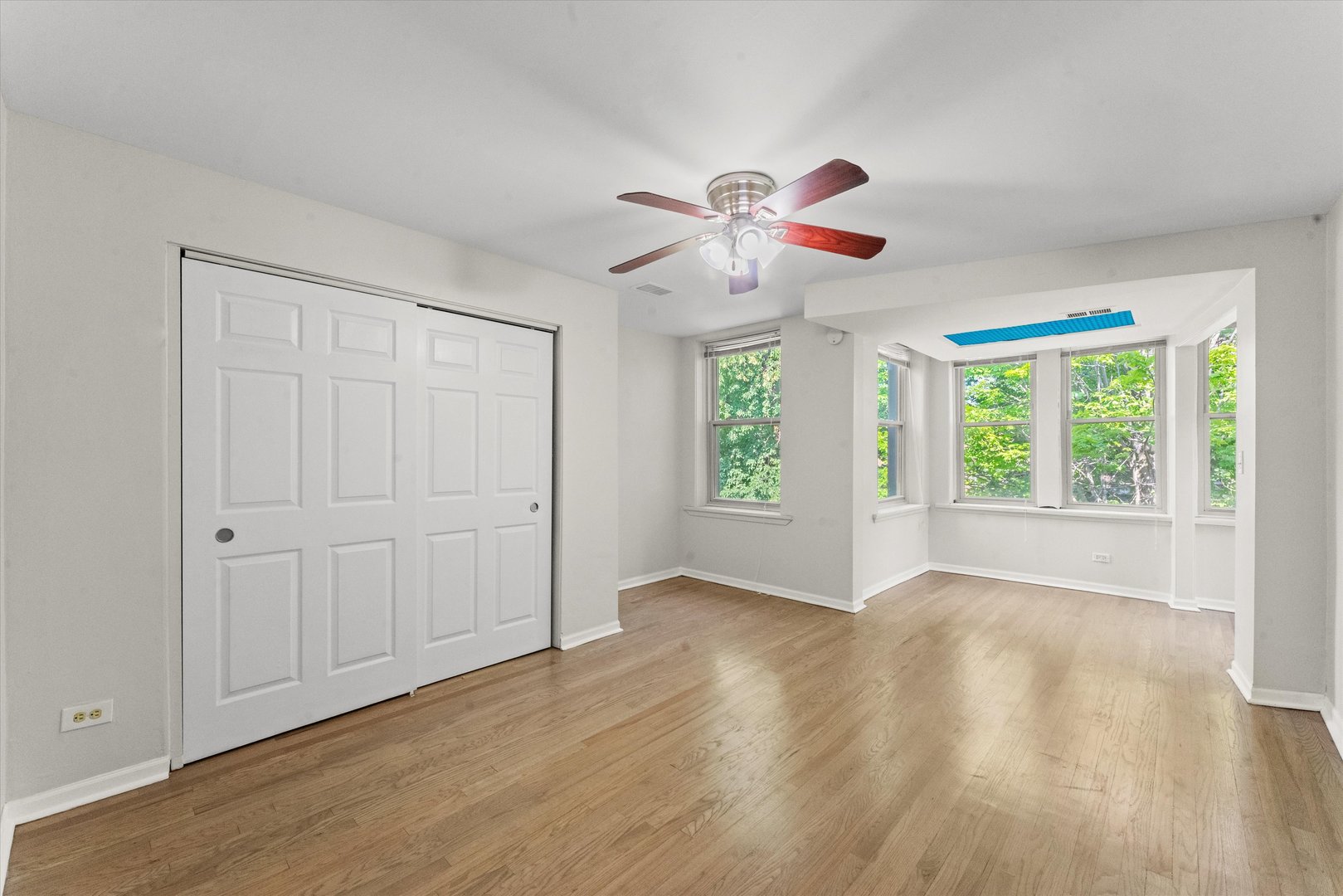 4846 North Keystone Avenue, Unit 2 Chicago, IL 60630 - Photo 7 of 12 a view of an empty room with a window and wooden floor