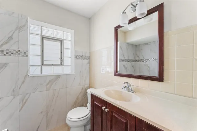 a bathroom with a sink a toilet and a mirror