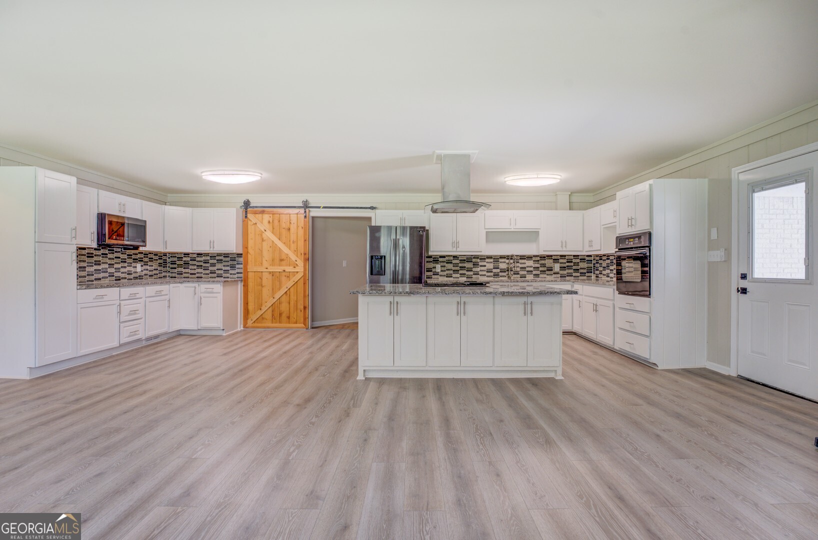 635 Jackson Lake Road Mansfield, GA 30055 - Photo 17 of 68 a large kitchen with a wooden floor and stainless steel appliances