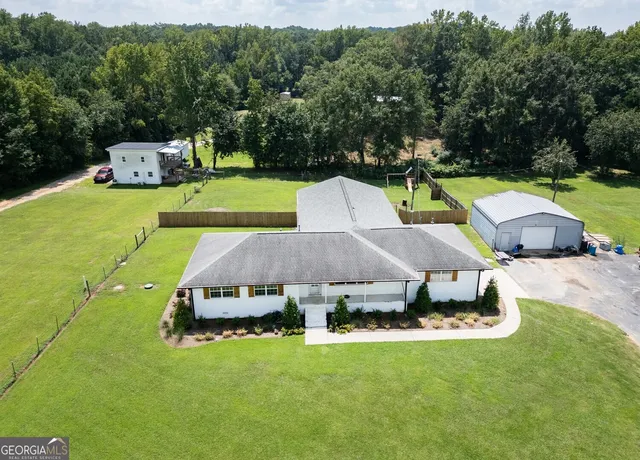 a aerial view of a house with swimming pool lawn chairs and a yard