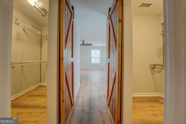 an empty room with wooden floor windows and ceiling fan