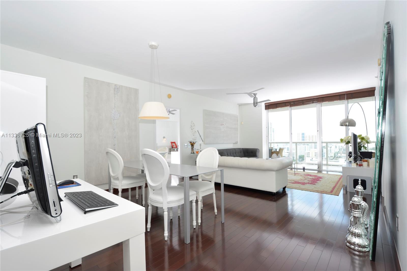 a living room with furniture a flat screen tv and a large window
