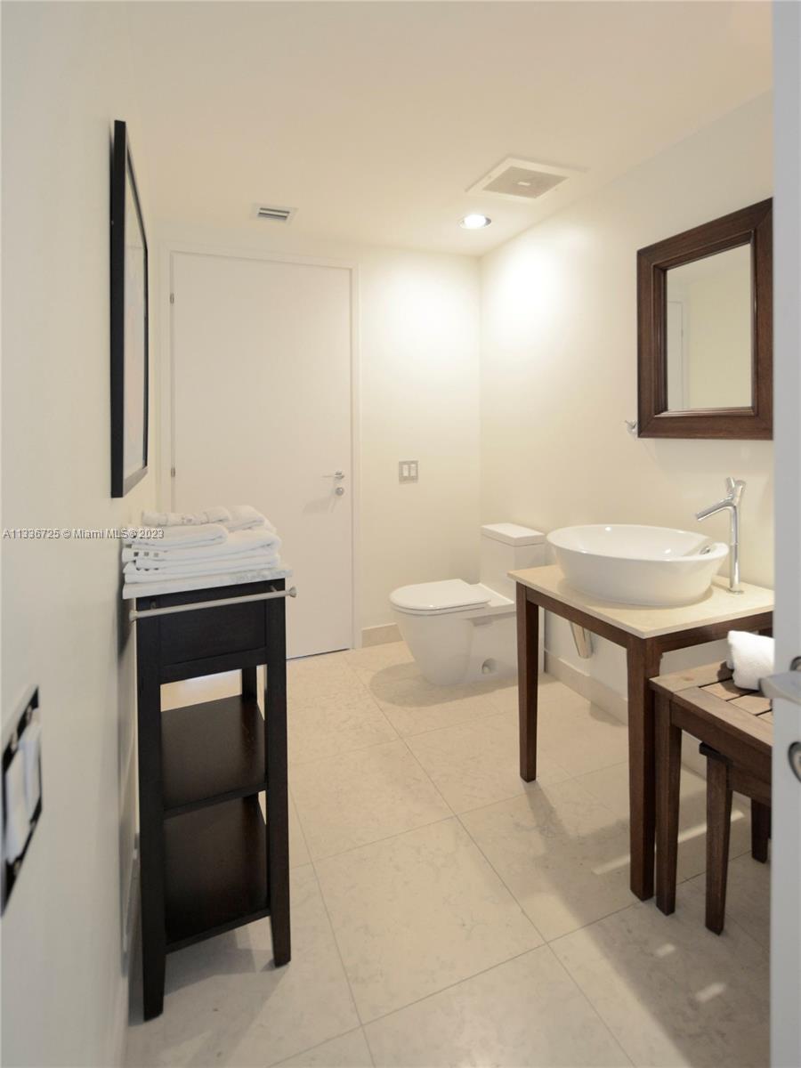 450 Alton Road, Unit 2006 Miami Beach, FL 33139 - Photo 24 of 34 a bathroom with a sink a toilet and mirror