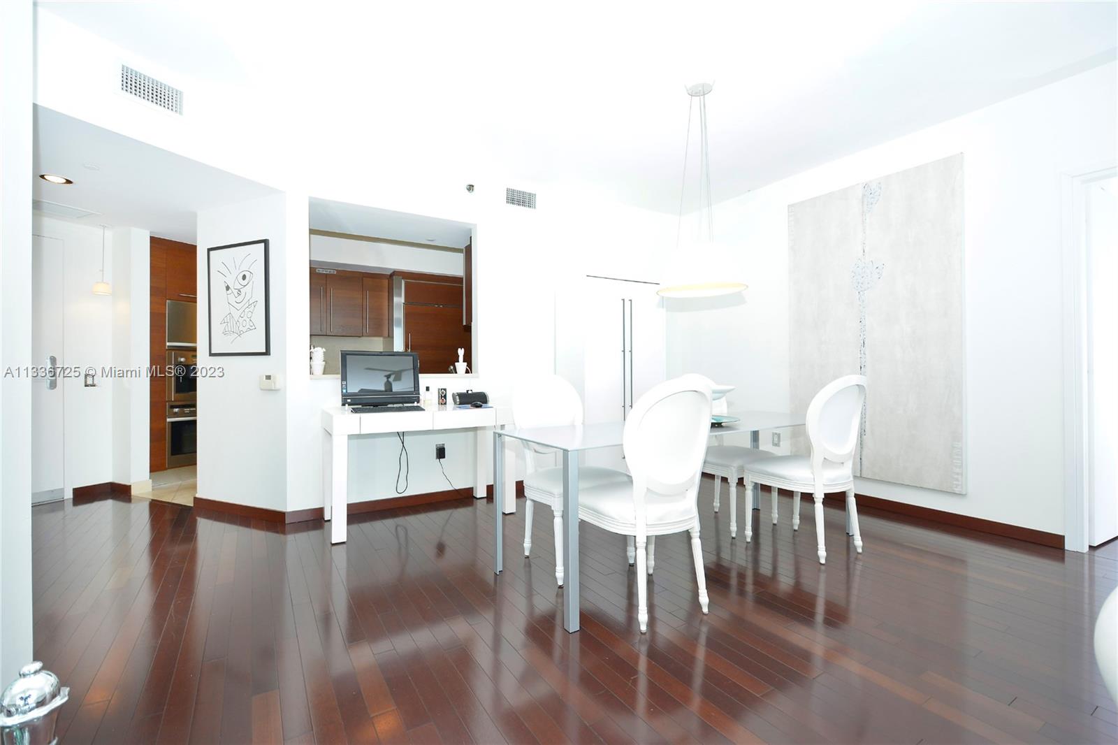 450 Alton Road, Unit 2006 Miami Beach, FL 33139 - Photo 4 of 34 a view of dining room and livingroom with furniture wooden floor a chandelier