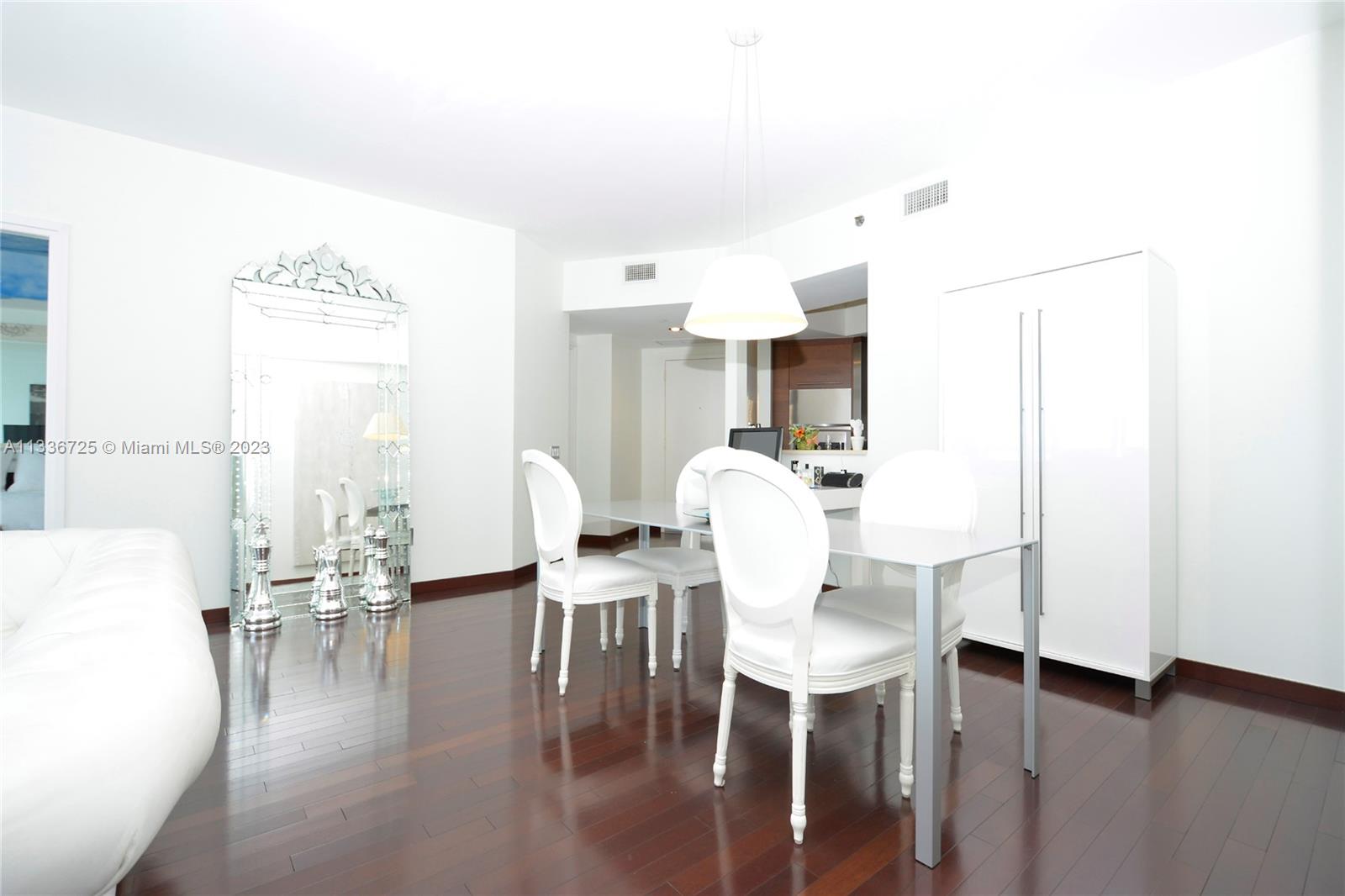 450 Alton Road, Unit 2006 Miami Beach, FL 33139 - Photo 5 of 34 a view of a dining room with furniture and wooden floor