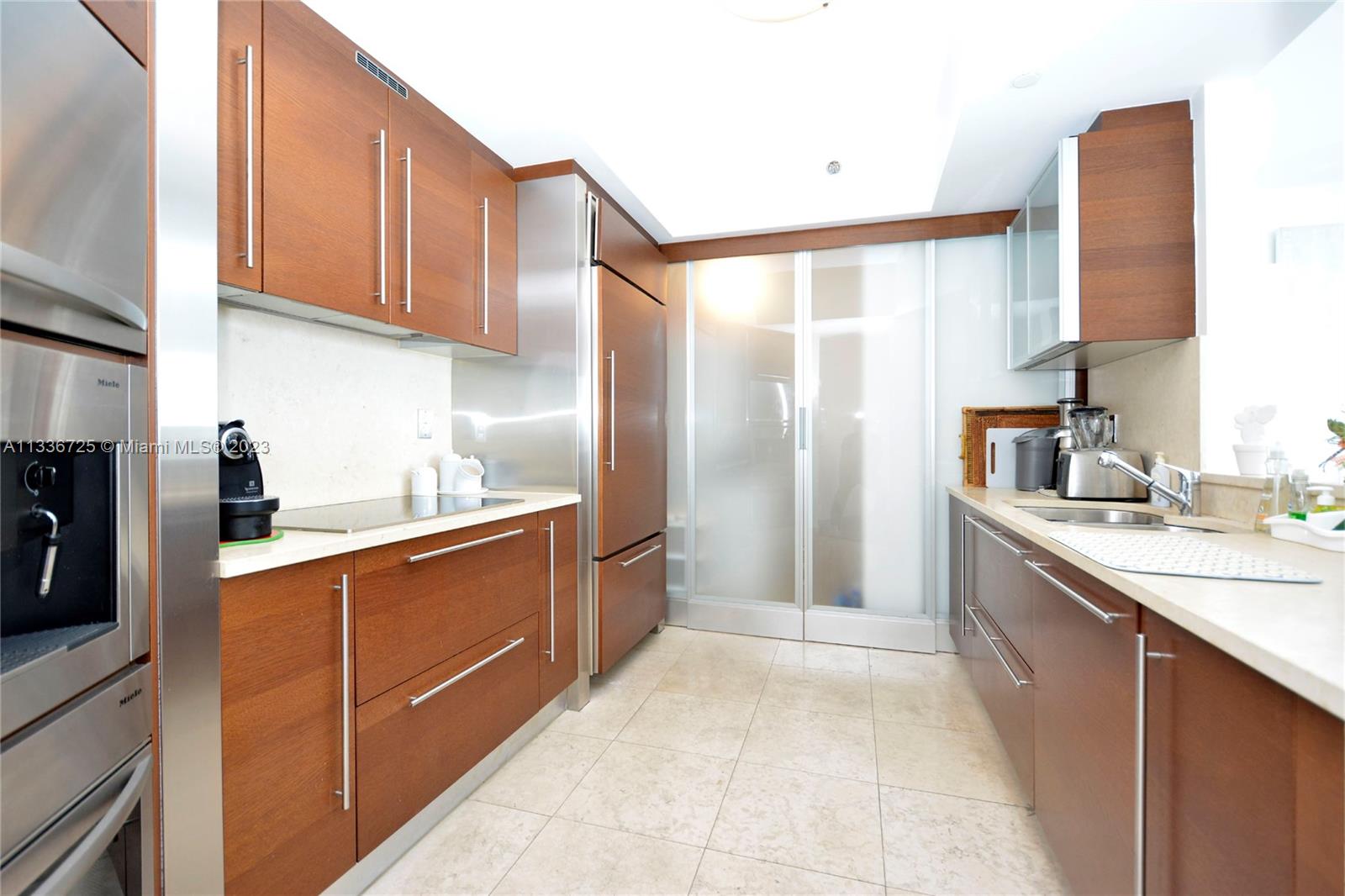 450 Alton Road, Unit 2006 Miami Beach, FL 33139 - Photo 9 of 34 a large kitchen with stainless steel appliances granite countertop a refrigerator and a sink