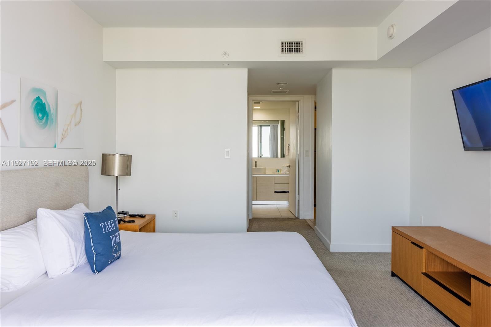 2602 East Hallandale Beach Boulevard, Unit R708 Hallandale Beach, FL 33009 - Photo 17 of 42 a bedroom with a bed and a lamp