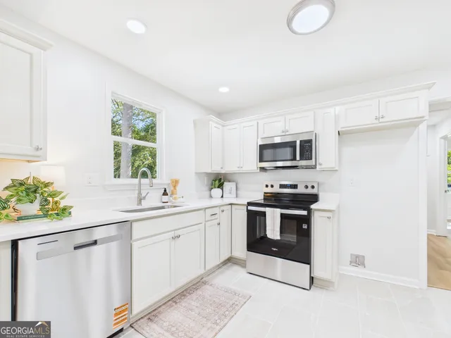 a large white bed in a room next to a window