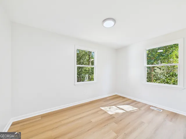 a view of a room with wooden floor and white walls