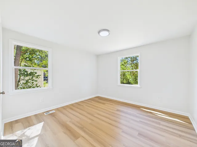 a view of a room with wooden floor and white walls
