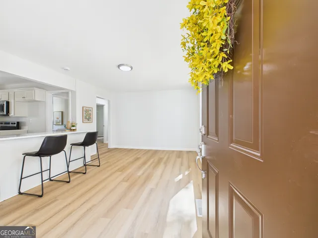 a view of a room with wooden floor and a potted plant