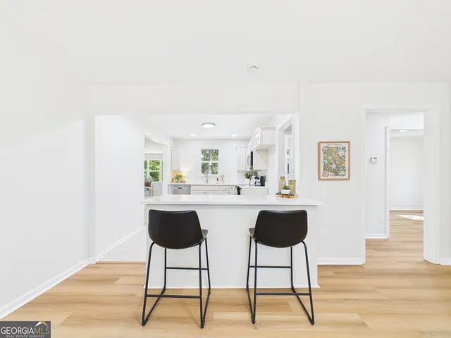 a view of workspace and kitchen with wooden floor