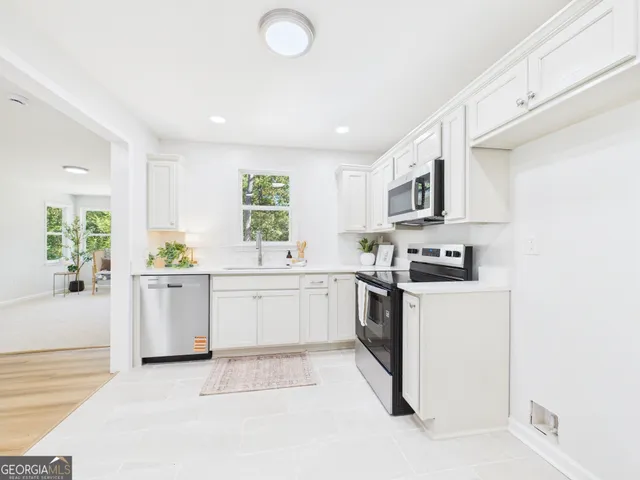 a room with a sink cabinets and a window
