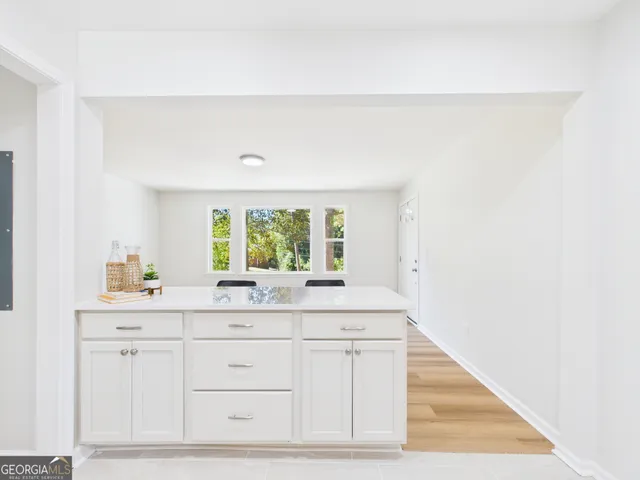 a kitchen with stainless steel appliances white cabinets and a window