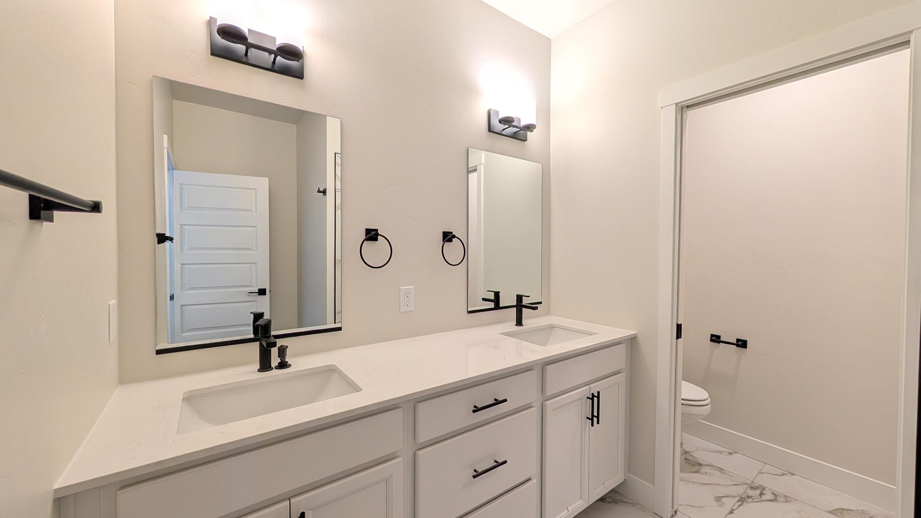 2463 Revere Road, Unit A Grand Junction, CO 81505 - Photo 9 of 13 a bathroom with a sink a toilet and a mirror