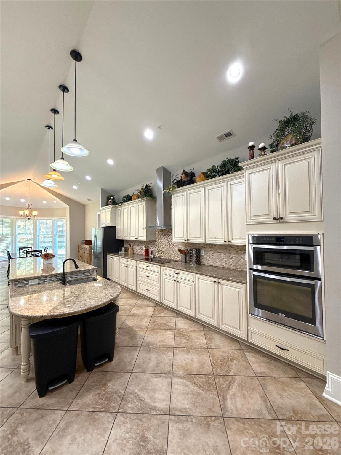 13931 Thompson Road Charlotte, NC 28227 - Photo 10 of 43 a large kitchen with kitchen island granite countertop a large counter top and white cabinets