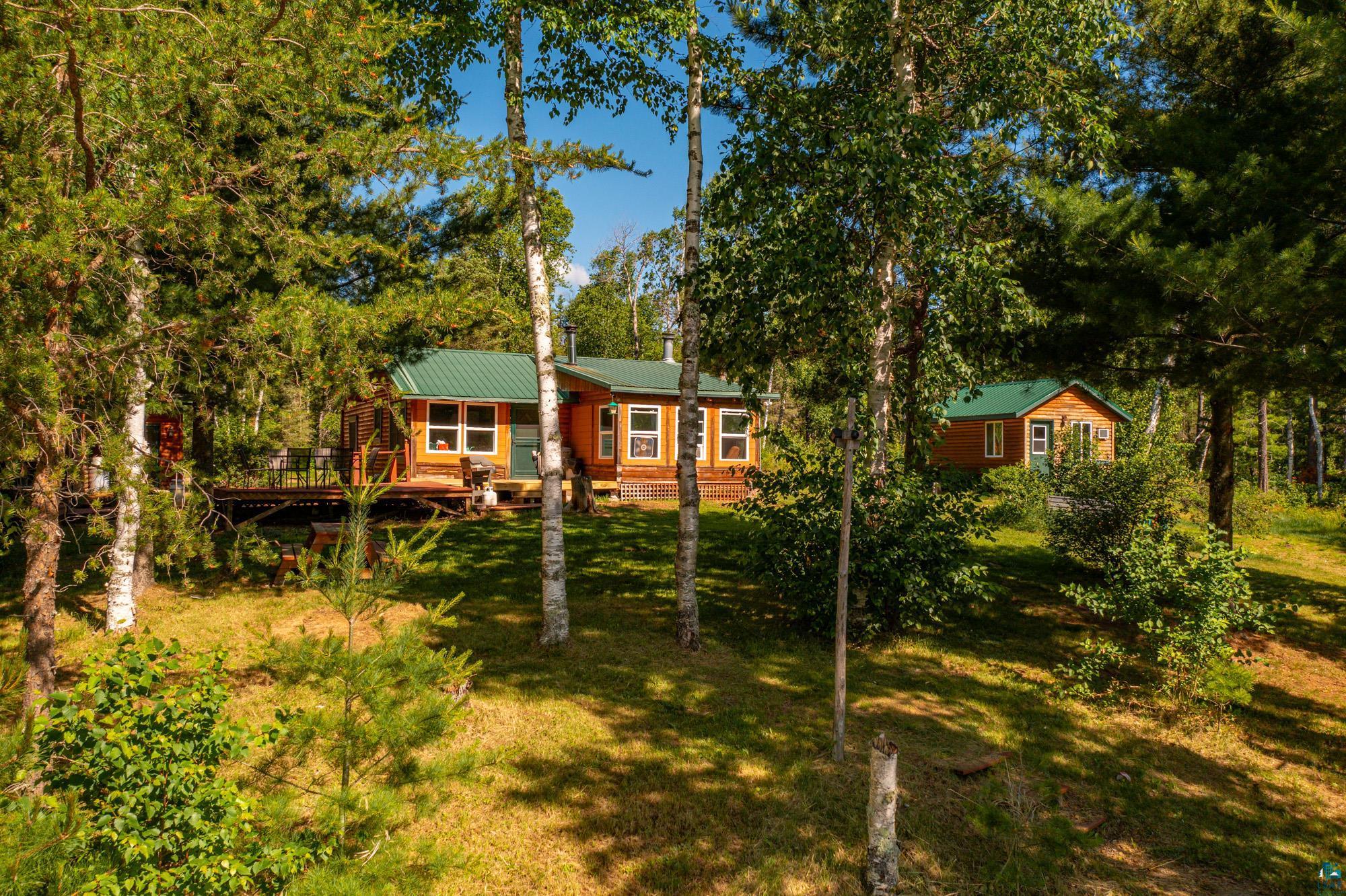 View of front of main cabin & studio with a wooden decks.