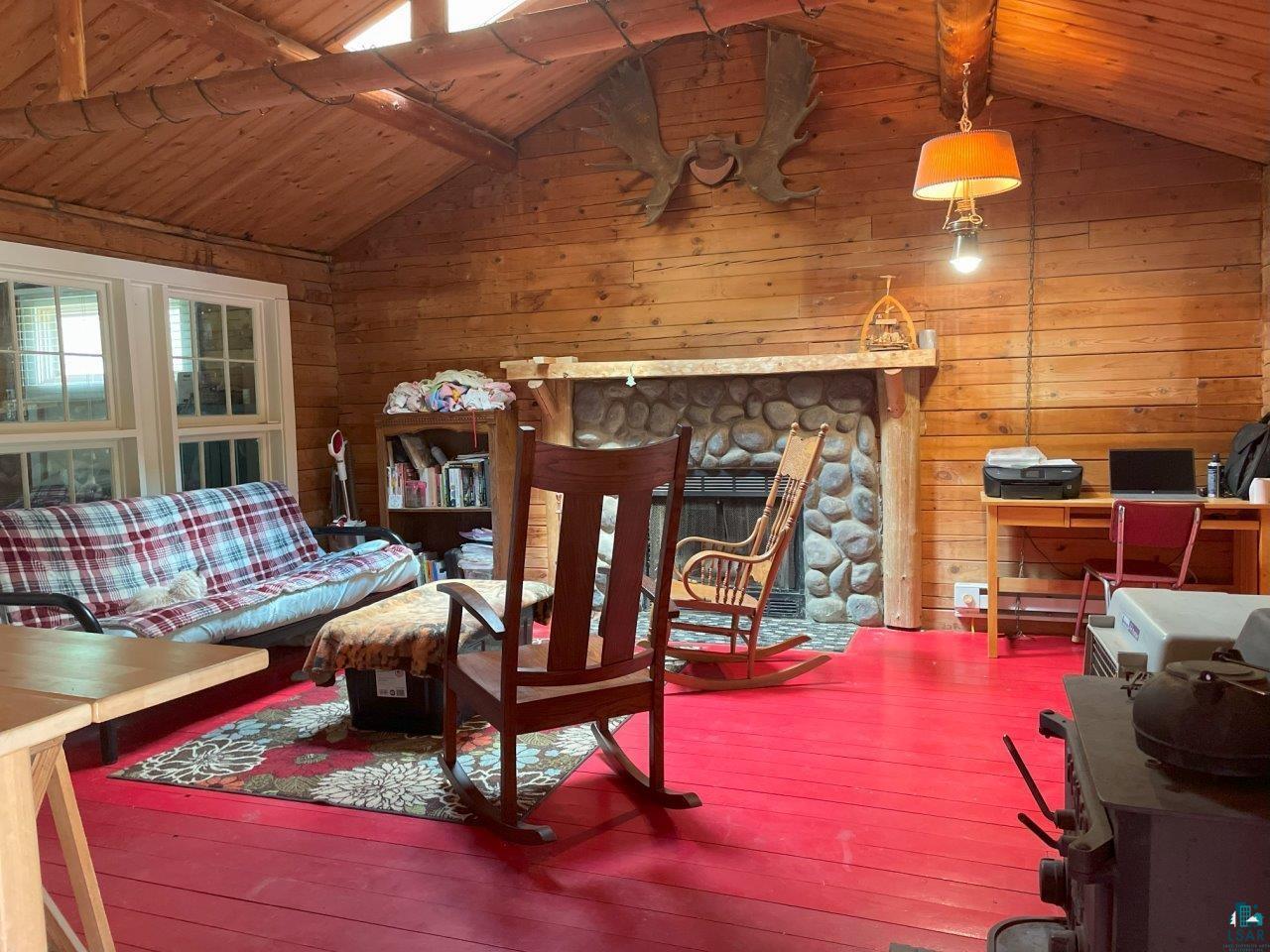 3420 Dewees Road Babbitt, MN 55706 - Photo 13 of 58 Living area featuring vaulted ceiling with log trusses & purlins; hardwood floors; skylight.