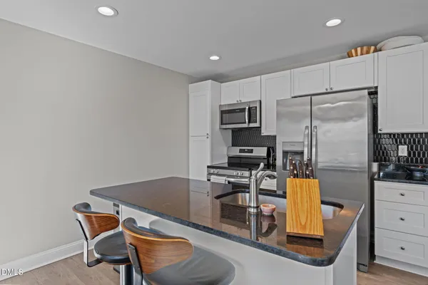 a kitchen with a refrigerator and table chair