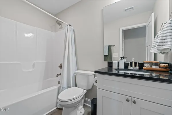 a bathroom with a granite countertop sink a toilet and a mirror