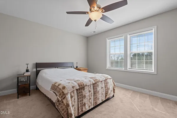 a bedroom with a bed chandelier and a window