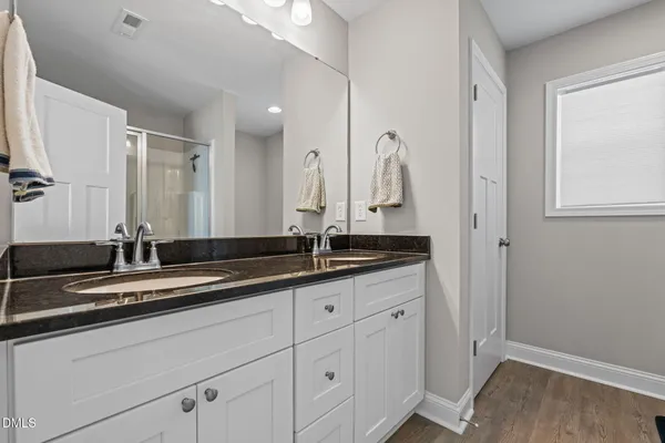 a bathroom with a double vanity sink and a mirror
