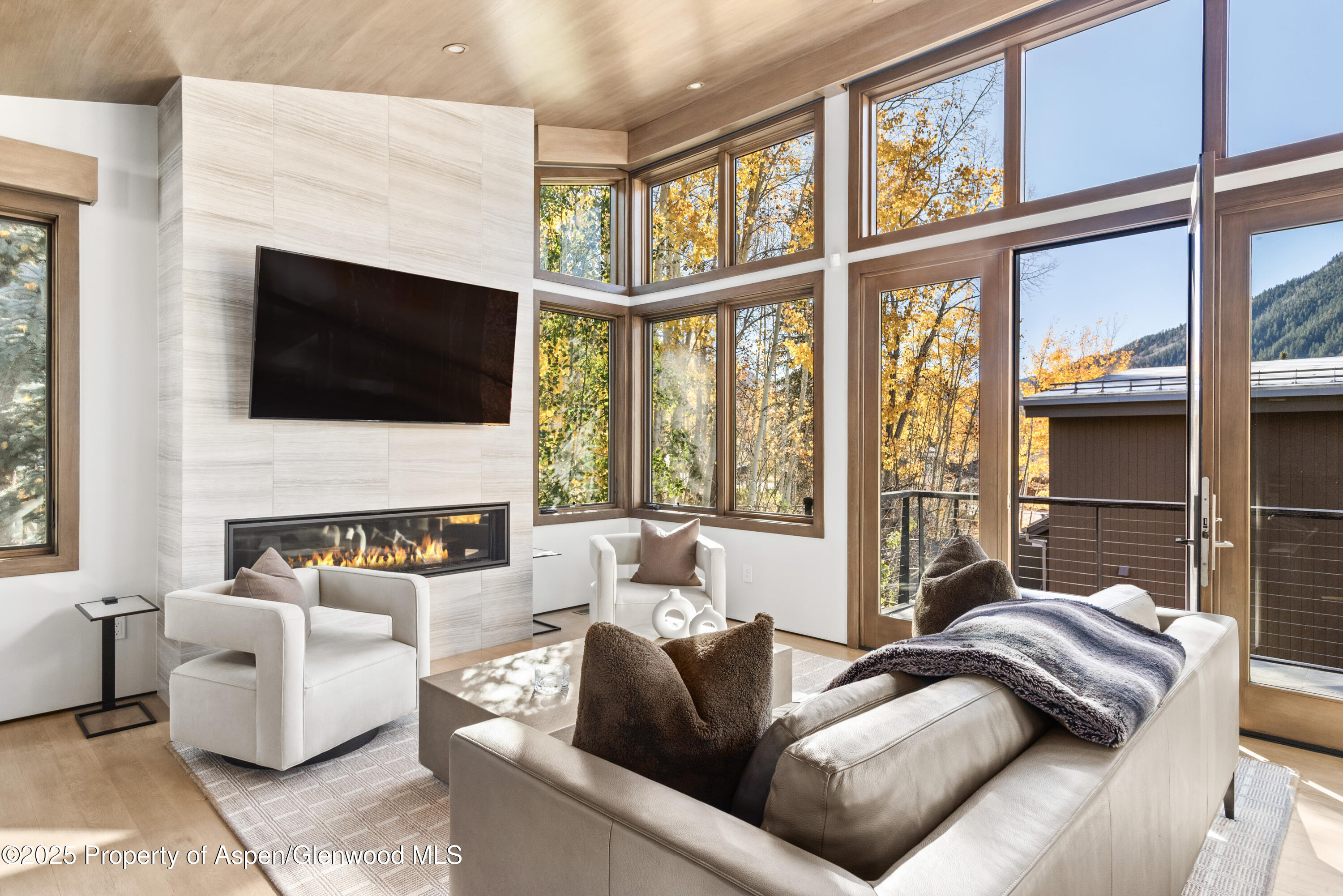 a living room with furniture a flat screen tv and a large window