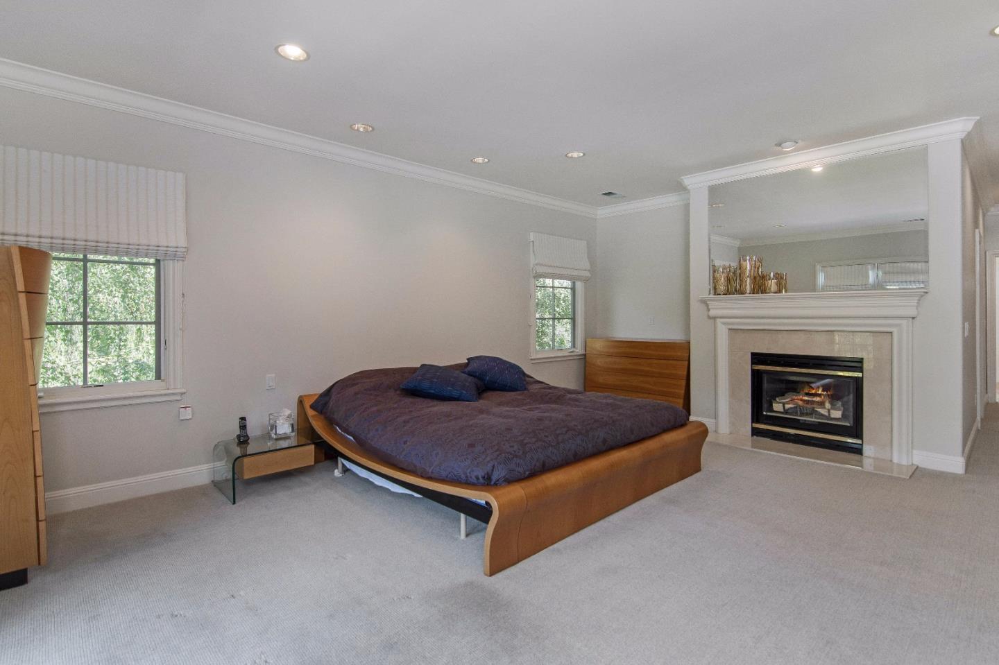 37 Valley Road Atherton, CA 94027 - Photo 20 of 26 a spacious bedroom with a bed and a fireplace