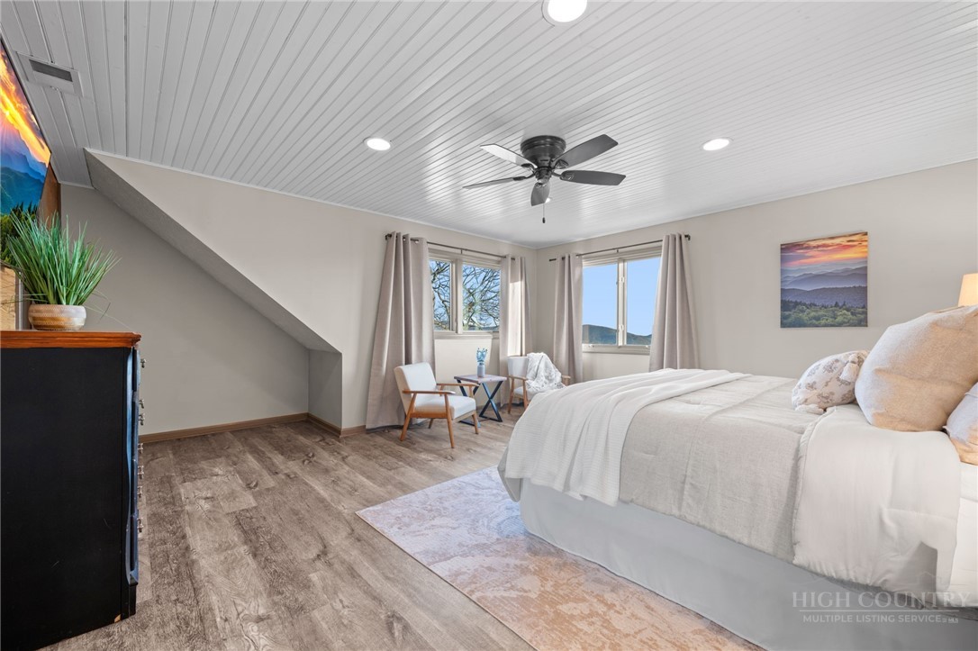 351 Windy Knob Trail Seven Devils, NC 28604 - Photo 27 of 50 a spacious bedroom with a large bed and a chandelier