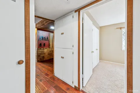 a view of a hallway with a livingroom and a way to rooms