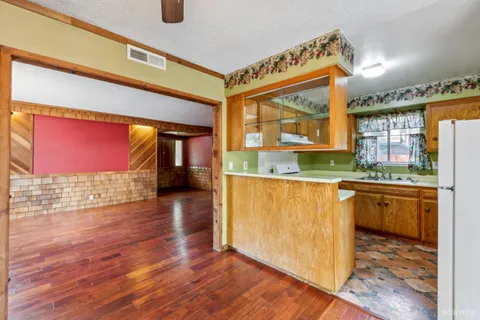 a kitchen with granite countertop a stove a sink and a wooden floors