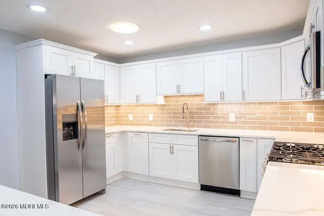 a kitchen with stainless steel appliances granite countertop a refrigerator and a stove