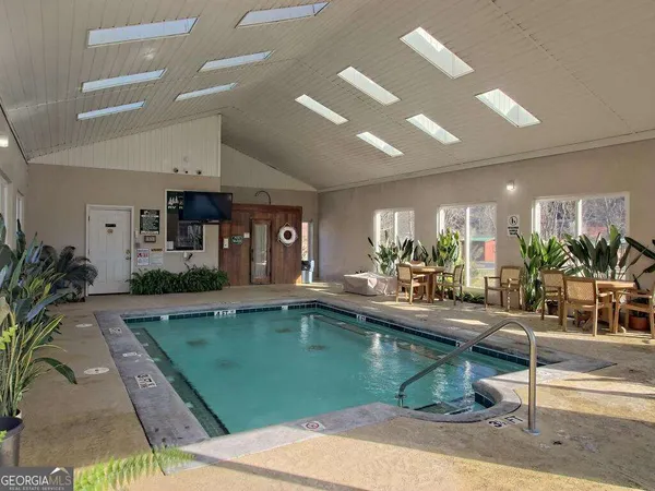 a room with lots of potted plants kitchen view and living room view