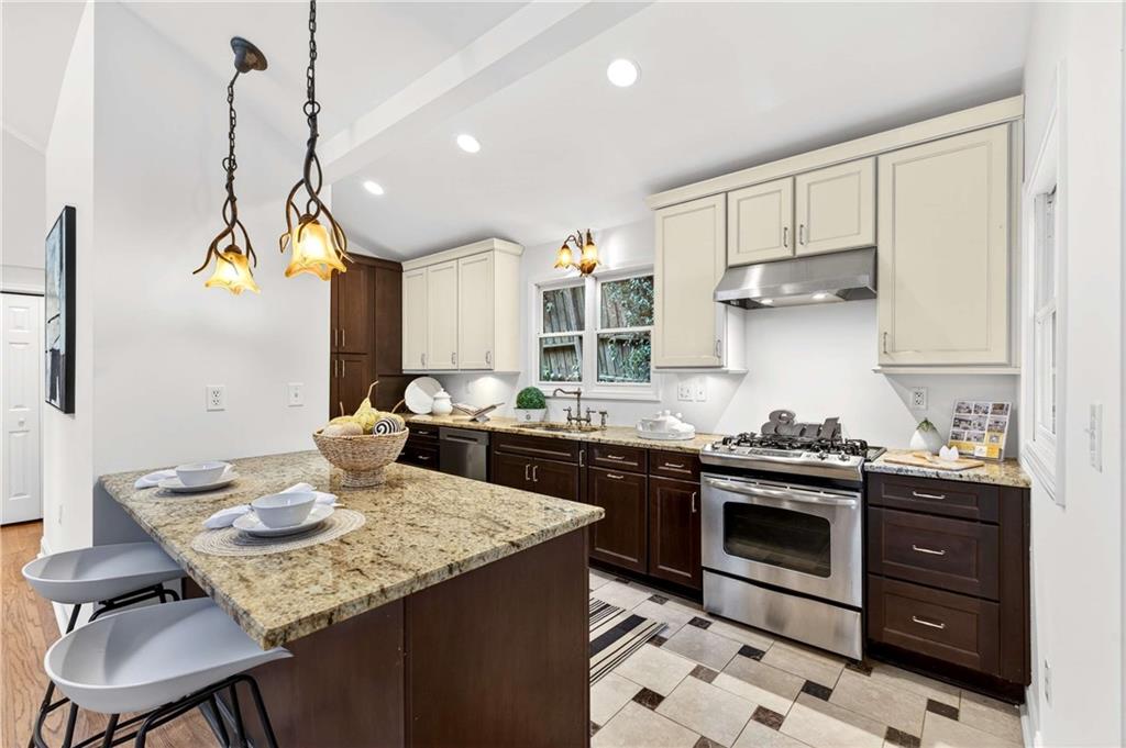 421 Emory Drive Northeast Atlanta, GA 30307 - Photo 12 of 42 a kitchen with a stove a sink a dining table and chairs