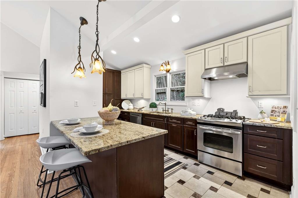 421 Emory Drive Northeast Atlanta, GA 30307 - Photo 13 of 42 a kitchen with stainless steel appliances granite countertop a sink a stove and a wooden floors