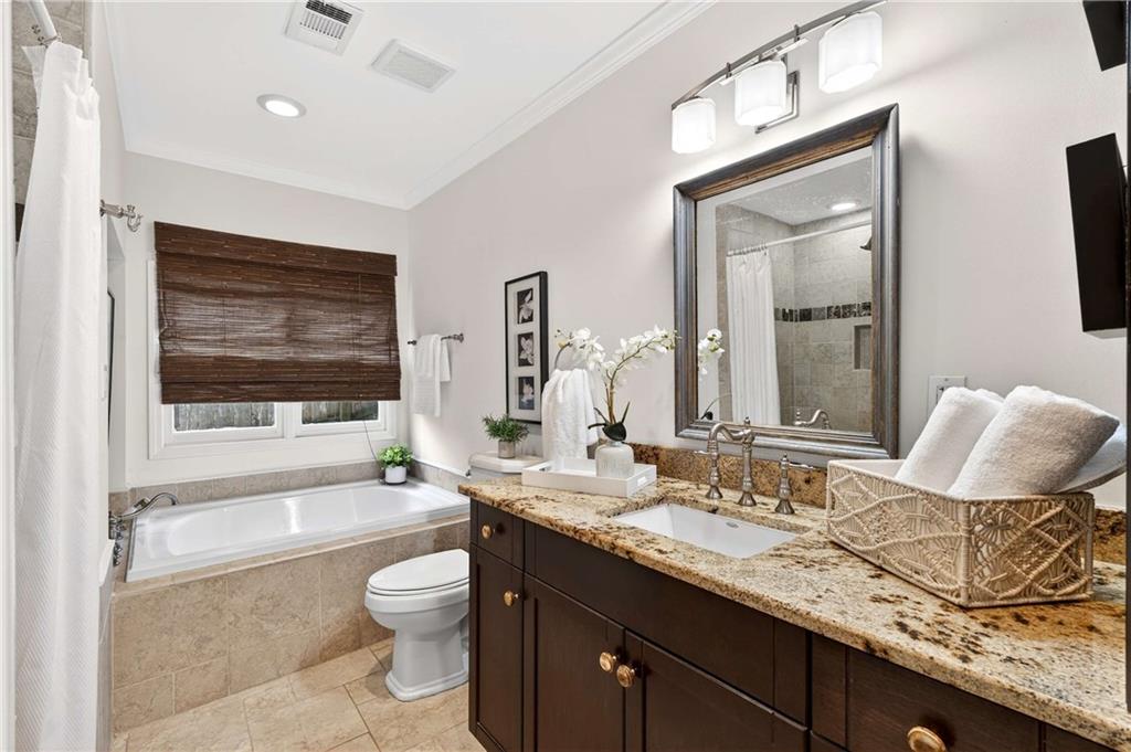 421 Emory Drive Northeast Atlanta, GA 30307 - Photo 25 of 42 a bathroom with a granite countertop sink toilet a mirror and bathtub
