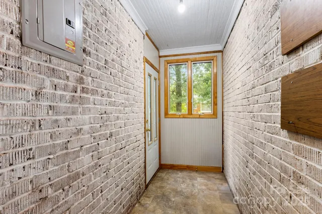 a view of a hallway with wooden floor and a bathroom