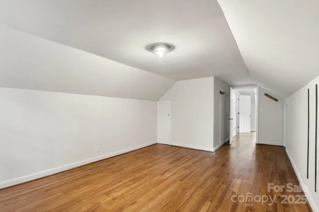 a view of a hallway with wooden floor and closet