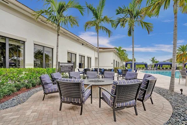 a palm tree sitting in front of a house with a big yard