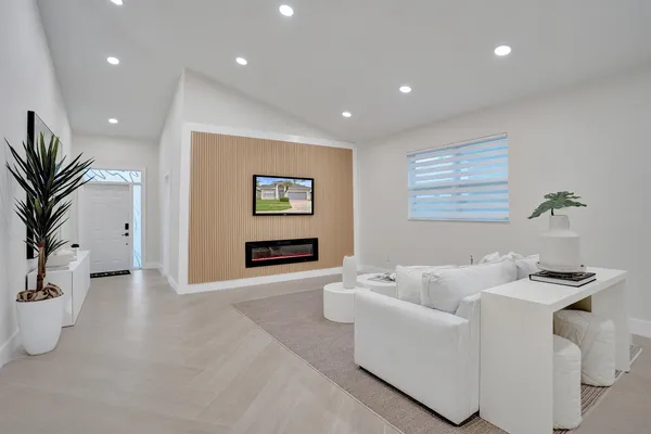 a living room with furniture a flat screen tv and a large window
