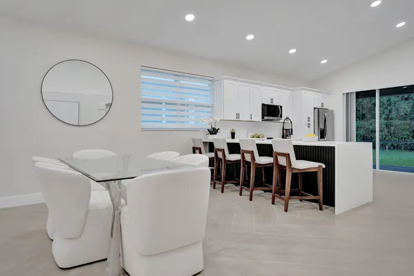 a large white kitchen with stainless steel appliances