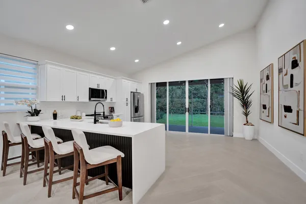 a large kitchen with stainless steel appliances granite countertop a stove top oven a sink and dishwasher